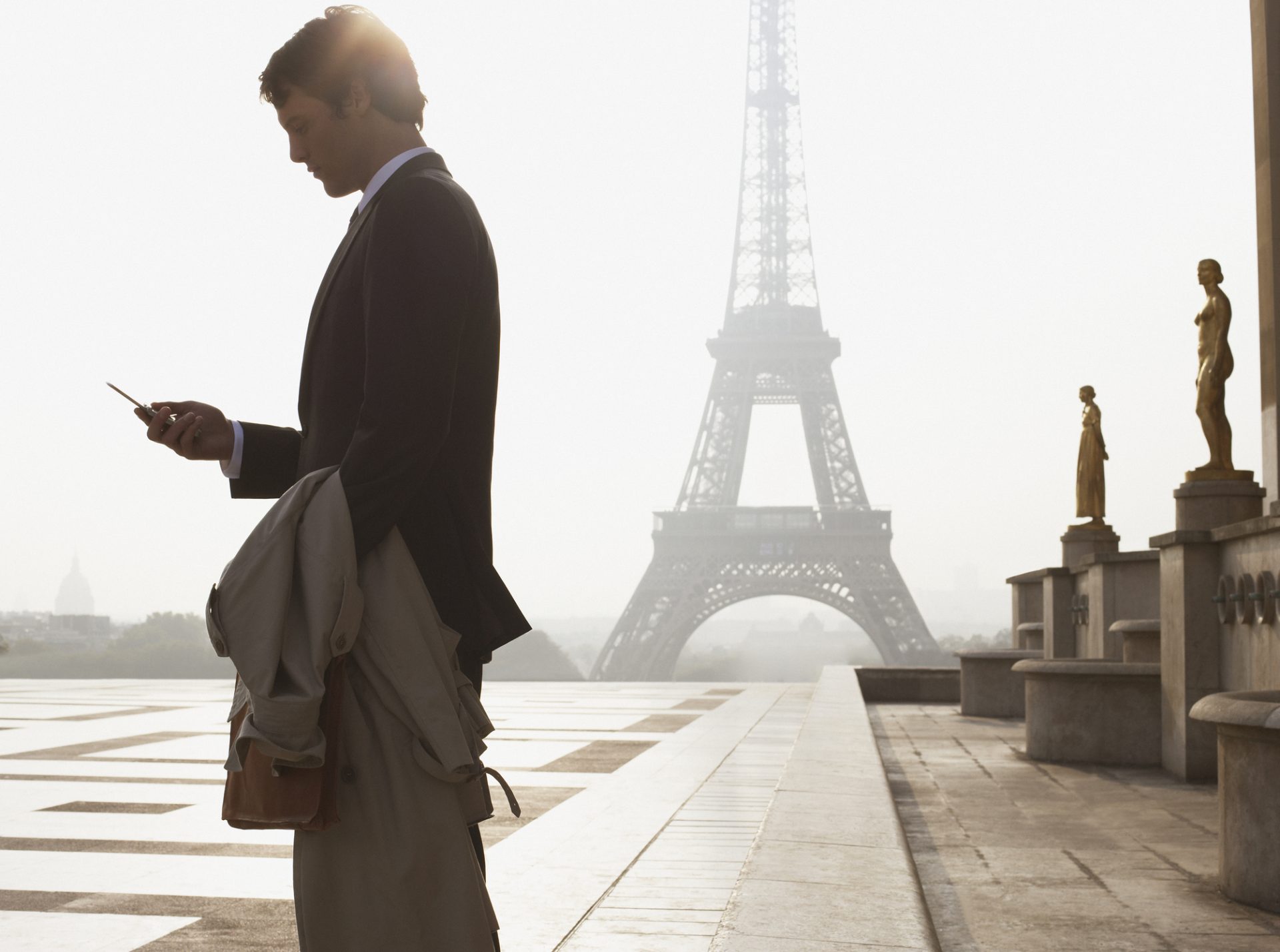 Businessman outdoors with cellular phone by Eiffel Tower