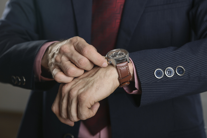 Businessman winding up his watch